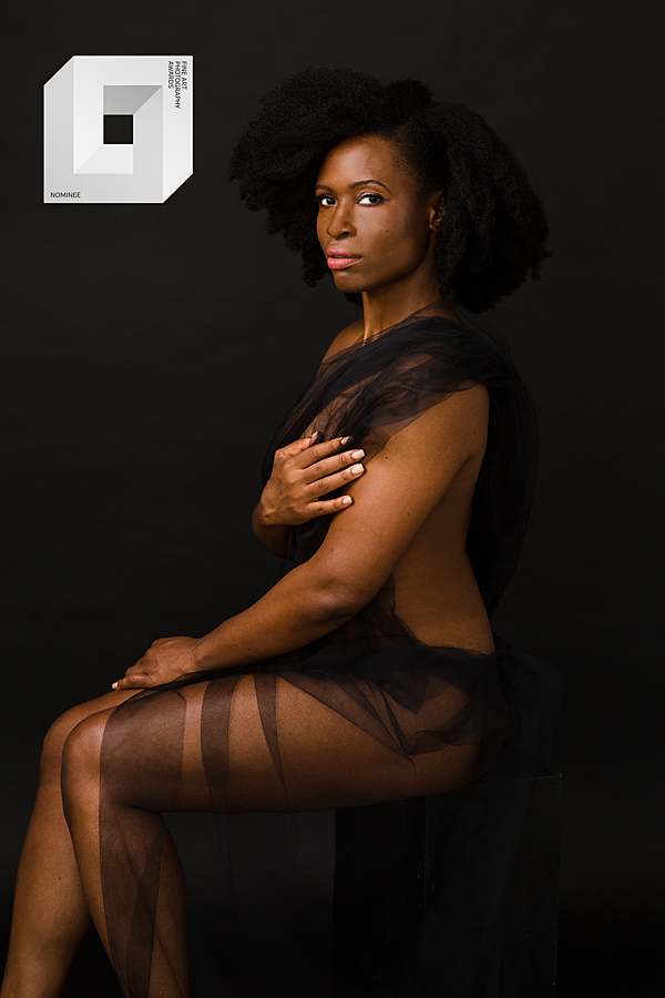 boudoir-naked-fine-art-portrait-with-black-woman-black-background-covered-in-black-tulle