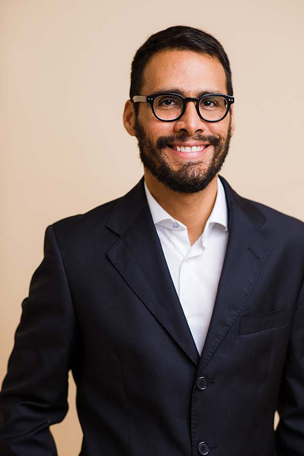 corporate-photography-business-portrait-of-man-in-navy-suit-white-shirt-wearing-glasses-smiling-by-headshot-photographer-london