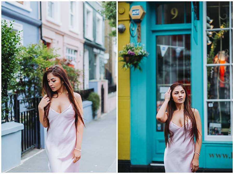 Woman in a satin dress posing on a pastel-colored street and in front of a teal shopfront in Notting Hill, London